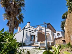 a swing in front of a house with a palm tree at EVH-113 Casa Martina in Tossa de Mar