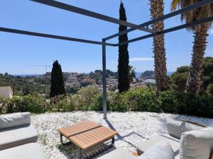 a patio with a table and chairs and palm trees at EVH-113 Casa Martina in Tossa de Mar