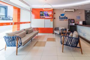 a lobby of a ups store with a couch and chairs at Luds Comfort Hotel in Ponta Grossa
