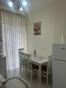 a kitchen with a table and chairs and a refrigerator at Apartament Oresti in Korçë