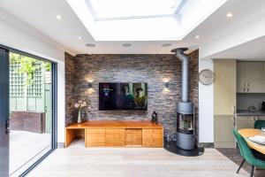 a living room with a fireplace and a tv on a brick wall at Apartment in Guildford with Parking in Stoughton