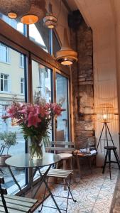 a room with a table with a vase of flowers on it at Flusshaus BnB Alicudi in Brugg