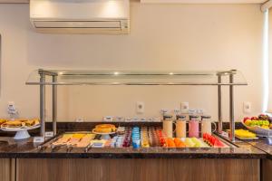 a buffet line with fruit and other food on a counter at Luds Comfort Hotel in Ponta Grossa