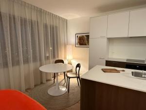 a kitchen with a table and a table and chairs at L'Excelsior Suites in Brasschaat