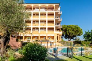 a tall yellow building with trees in front of it at Leo Canela in Isla Canela