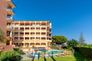 a large building with a swimming pool in front of it at Leo Canela in Isla Canela