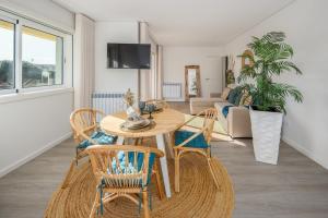 a living room with a wooden table and chairs at Aurora do Furadouro II in Ovar