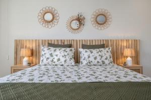 a bedroom with a bed with two mirrors on the wall at Aurora do Furadouro II in Ovar +9 photos
