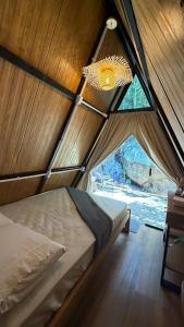 a room with a bed in a tent with a window at Cabana no Morro do Macaco in Bombinhas