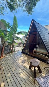 a tent on top of a wooden deck with a bench at Cabana no Morro do Macaco in Bombinhas