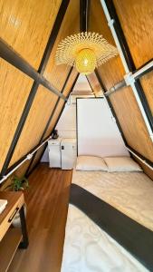 a room in a tent with a bed and a chandelier at Cabana no Morro do Macaco in Bombinhas