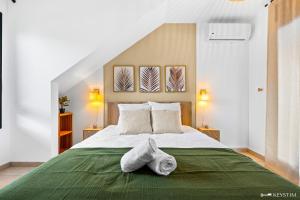 a bedroom with a large bed with towels on it at Koté La Savan' in Saint-Paul
