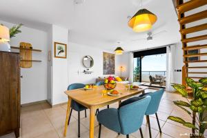 a dining room with a wooden table and blue chairs at Koté La Savan' in Saint-Paul