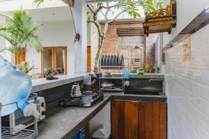 a kitchen counter with a sink and a mirror at Kayuma House Canggu in Canggu