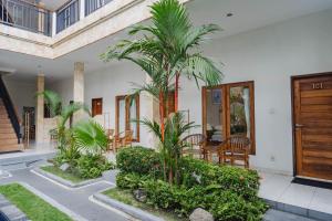 a courtyard with palm trees in a house at Kayuma House Canggu in Canggu