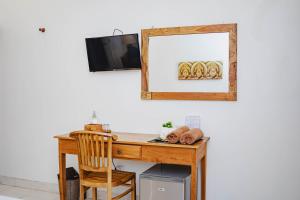 a wooden desk with a mirror and a wooden chair at Kayuma House Canggu in Canggu
