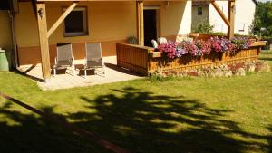 two chairs and a fence with flowers in a yard at Rennerhof-Siebeneichen Fewo Laubfrosch in Sulzbach-Rosenberg