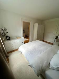 a bedroom with a white bed and a white dresser at Suite JULIETTE Chambre d'hôte de charme in Mulhouse +11 photos