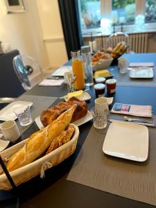 a table topped with a table with a basket of bread at Suite JULIETTE Chambre d'hôte de charme in Mulhouse