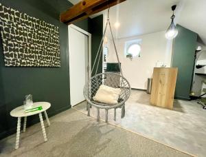a room with a swinging chair and a table at L'Appart'Anjou in Cantenay-Épinard +24 photos