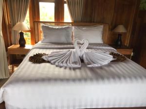 a couple of white towels on a bed at Mayong Awan Cita in Munduk
