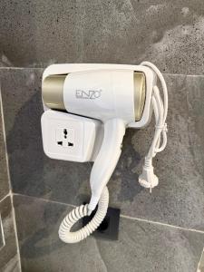 a white electric hair dryer sitting on a wall at Studio plein centre-ville ! in Fez