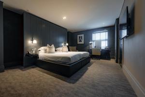 a hotel room with a large bed and a desk at Dakota Eurocentral in Motherwell