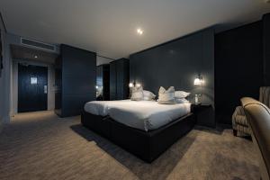 a bedroom with a large bed with a black wall at Dakota Eurocentral in Motherwell