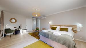a bedroom with a large bed and a desk at Villa "La Recrée Toulousaine " Clim & SPA-12 couchages in Cugnaux +78 photos