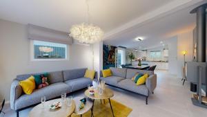a living room with a couch and two tables at Villa "La Recrée Toulousaine " Clim & SPA-12 couchages in Cugnaux