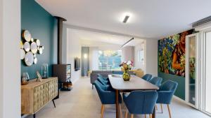 a living room with a table and blue chairs at Villa "La Recrée Toulousaine " Clim & SPA-12 couchages in Cugnaux