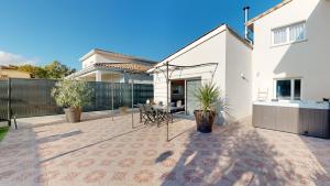 a patio with a table and chairs in a house at Villa "La Recrée Toulousaine " Clim & SPA-12 couchages in Cugnaux