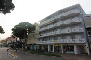 a large building with white balconies on a street at Residence Rondinelle in Lignano Sabbiadoro