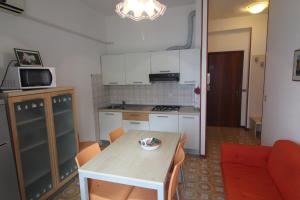 a small kitchen with a table and a couch at Residence Rondinelle in Lignano Sabbiadoro +5 photos