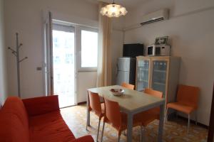a living room with a table and a kitchen at Residence Rondinelle in Lignano Sabbiadoro