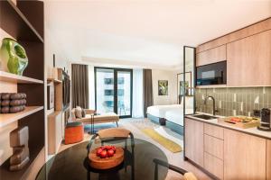 a hotel room with a kitchen and a bedroom at Kennedy 89 Hotel Frankfurt, part of Hyatt in Frankfurt