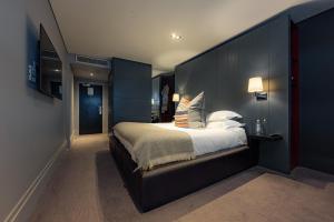 a bedroom with a large bed with blue walls at Dakota Eurocentral in Motherwell +42 photos