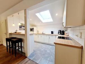 a large kitchen with white cabinets and a skylight at Ferienhaus Hummel in Böhl +12 photos