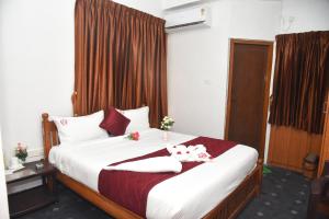 a bedroom with a bed with two stuffed animals on it at RD Hotel-Near Anna Statue in Perundurai