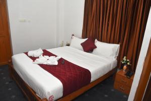 a bedroom with a bed with white towels on it at RD Hotel-Near Anna Statue in Perundurai +4 photos