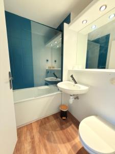a bathroom with a sink and a tub and a toilet at Kyriad Blois Sud - Vineuil in Vineuil +50 photos
