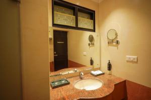a bathroom with a sink and a large mirror at THE SEASHORE HOTEL in Kanyakumari +31 photos