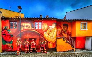 a mural on the side of a building with people on it at Casa da Avó Maria in Podence +6 photos