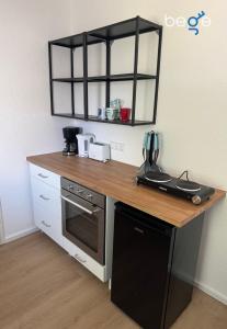 a kitchen with a wooden counter top and a black oven at BEGE APARTMENTS BalanceBase in Philippsburg