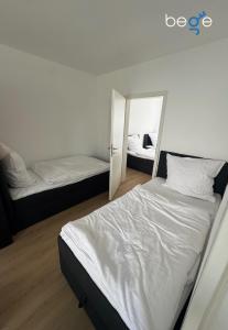 a bedroom with two beds and a mirror at BEGE APARTMENTS BalanceBase in Philippsburg