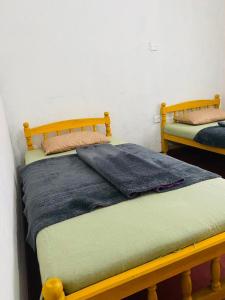 two twin beds sitting next to each other in a room at Siloneeds HOSTEL in Nuwara Eliya