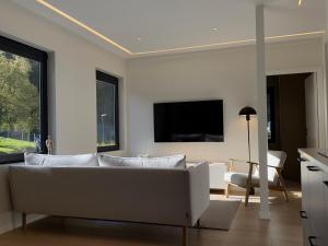a living room with a couch and a flat screen tv at Odda Gangdal Apartments in Odda
