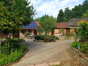 a house with a building with a solar roof at Magdalen The Old Dairy in Winsham