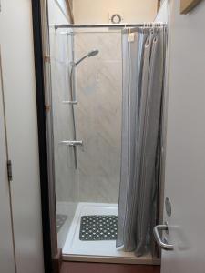 a shower with a glass door in a bathroom at Magdalen The Old Dairy in Winsham
