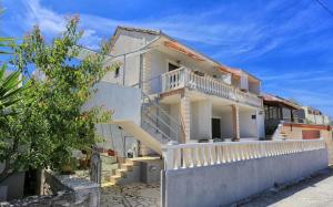 a white house with a white fence in front of it at Apartmani Suzi in Slatine